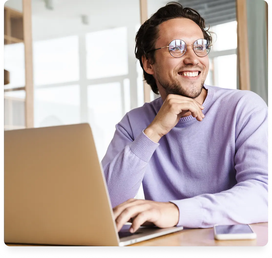 Smiling Ubee mortgage broker in front of his computer